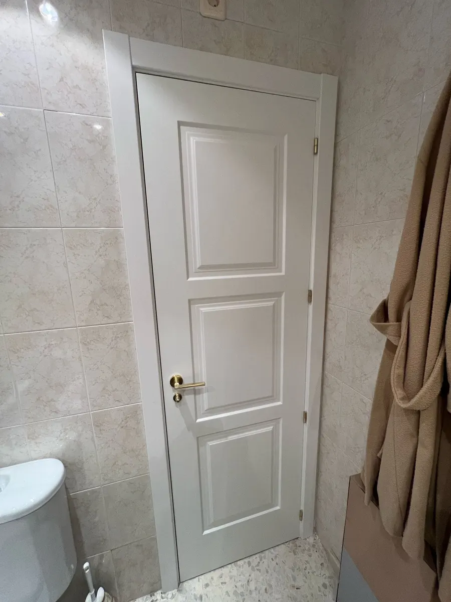 Puerta lacada montada en un baño alicatado